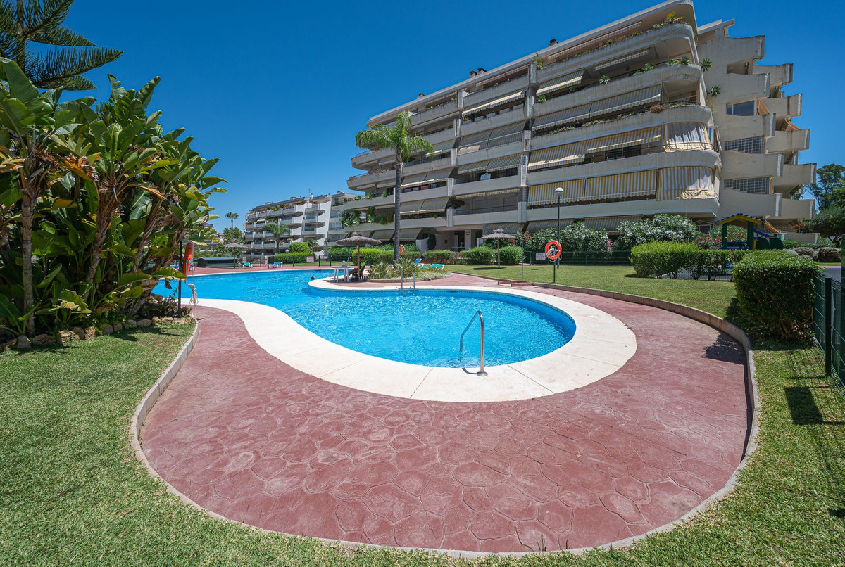 Luxurious Guadalmina apartment with sea views, terraces, and modern amenities.